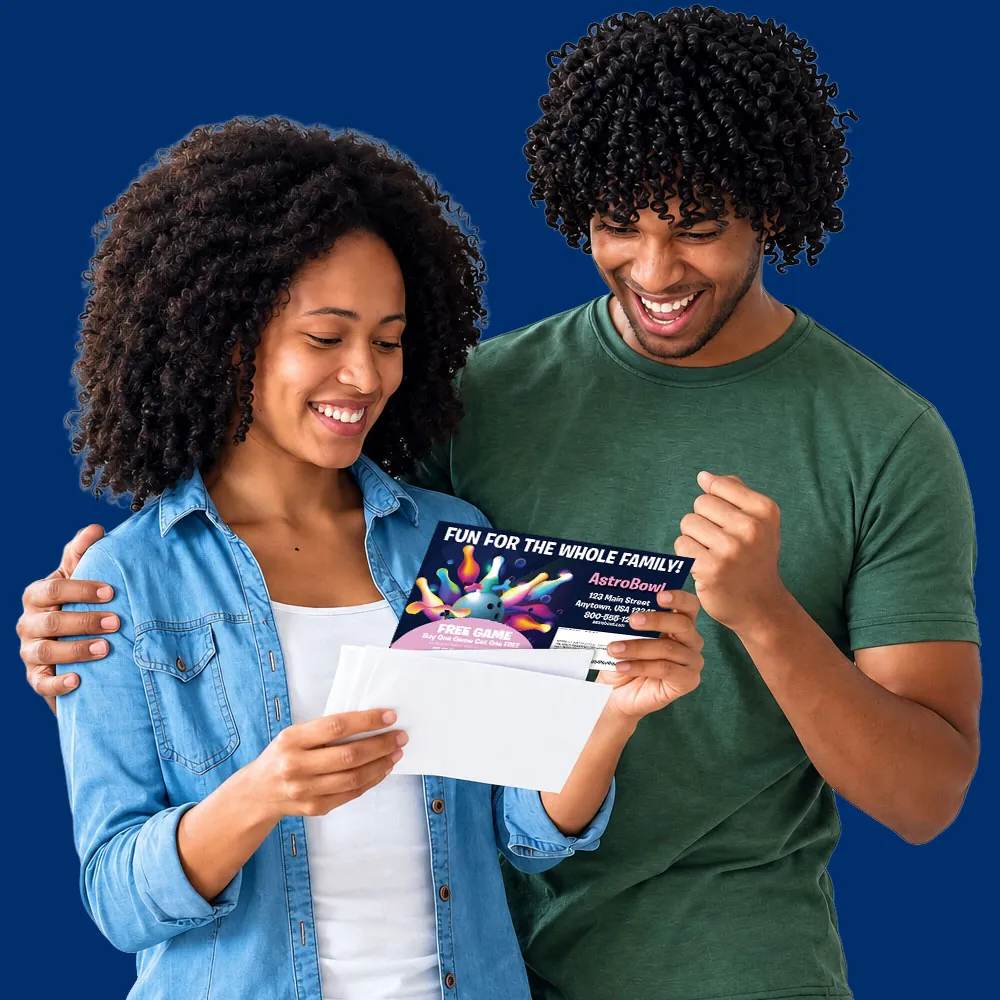 Couple smiling while reading a Valpak postcard they received in the mail